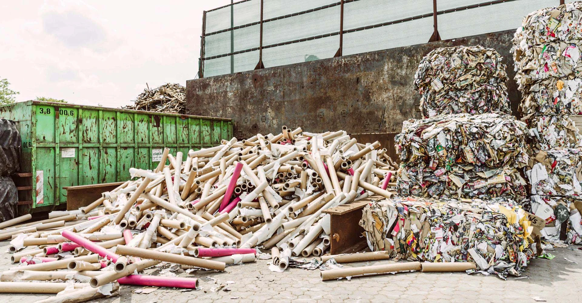 Papprollen und gepresste Papierblöcke auf dem Werkhof