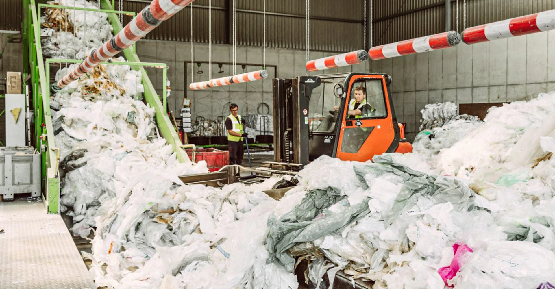 Ein Berg Kunststoffabfälle und im Hintergrund ein Gabelstapler
